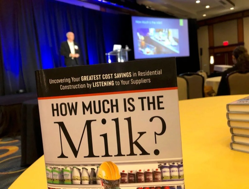 The book on a table at an industry conference while Ken presents on stage